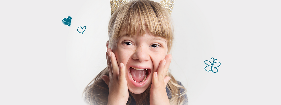 Close up photo of a young girls face, she is holding her face and acting exciting or surprised